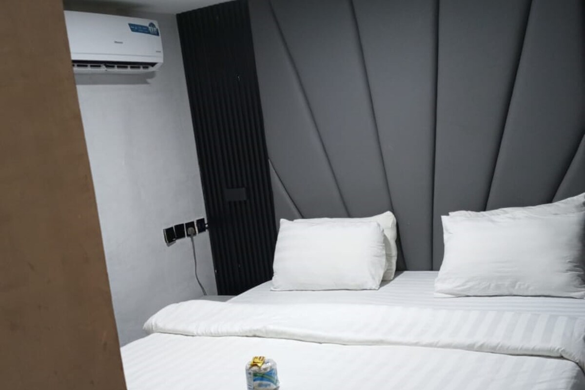 Een hotelkamer met een bed, een ronde tafel en een airconditioning.