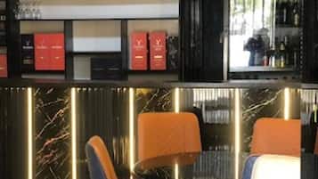 A bar area with a black countertop, red boxes on shelves, and a Beck's refrigerator.