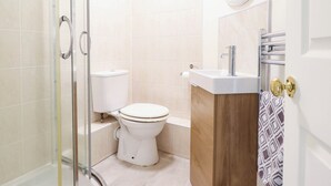 A bathroom with a toilet, a sink, a mirror, and a shower enclosure. - HARBOUR COTTAGE, pet friendly, country holiday cottage in Barmouth (Barmouth)
