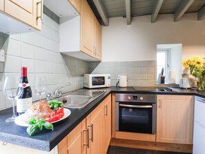 Une cuisine équipée d’un four à micro-ondes, d’un grille-pain, d’un évier et d’un four traditionnel.