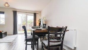 Spiseplads med et bord, stole og udsigt til det fri.