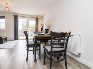 A dining area with a table, chairs, and a view of the outdoors. - HIGHER GORSE, pet friendly, with a garden in Roundswell (Barnstaple)