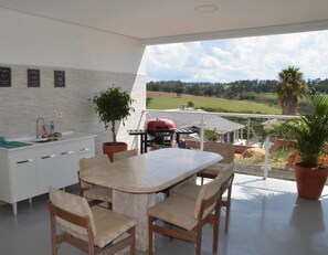 Een moderne keuken met een eetgedeelte, een barbecue en uitzicht op het landschap.