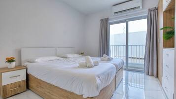 Quarto moderno com cama de madeira, mesa de cabeceira, cômoda e varanda com cortinas.