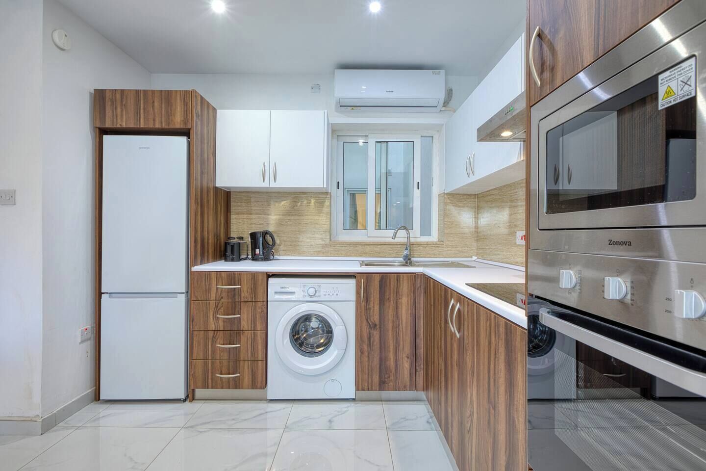 A modern kitchen with a built-in washer, a sink, and a stove.