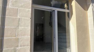 A building entrance with a glass door and a stone facade.
