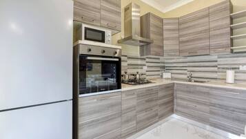 A modern kitchen with a built-in oven, microwave, and gas stove.