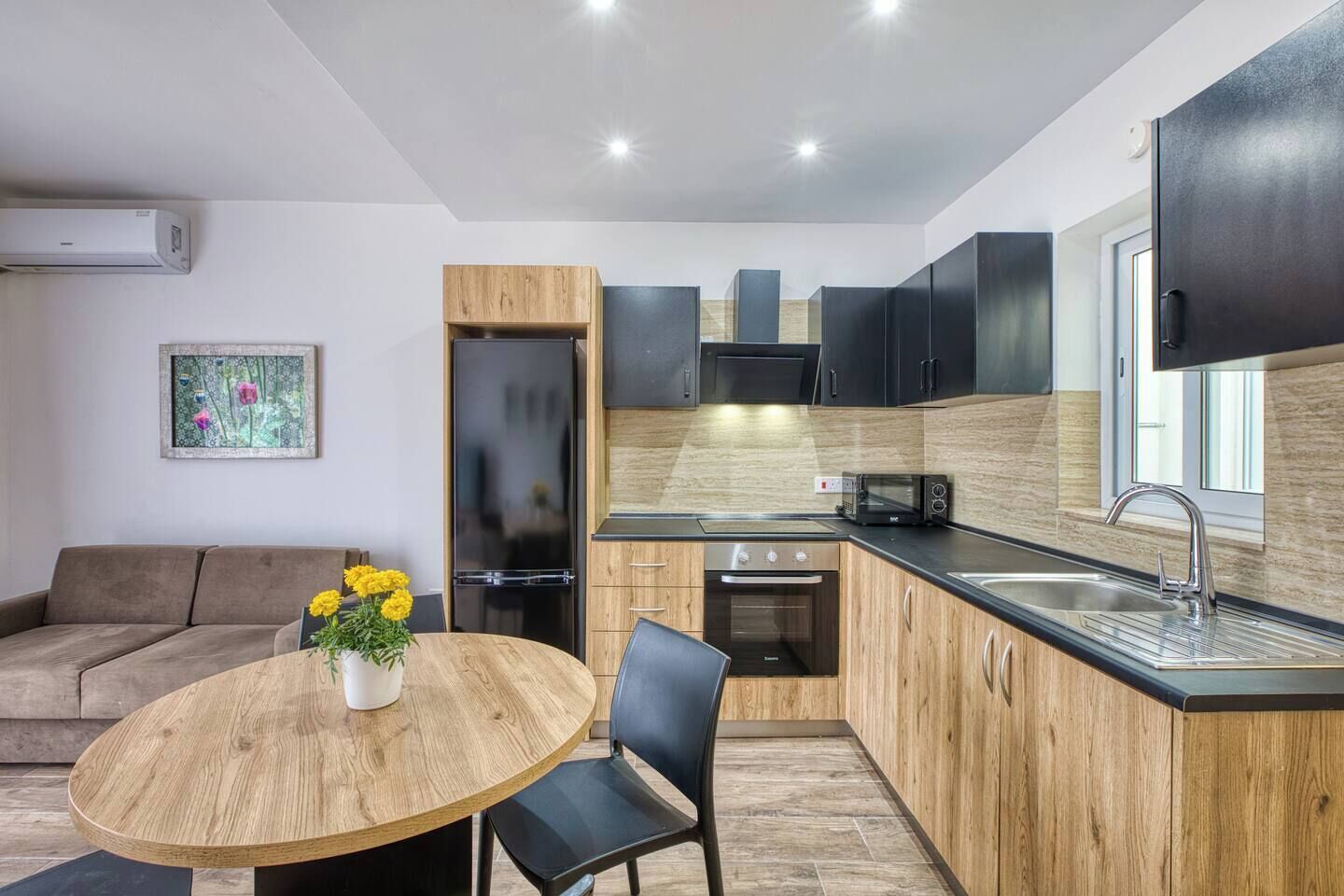 A modern kitchen with a built-in oven, microwave, and a sink.