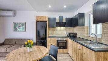 A modern kitchen with a built-in oven, microwave, and a sink.