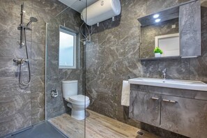 A modern bathroom with a glass shower enclosure, a toilet, and a vanity with a sink. - Modern, Central 1BR Penthouse – Valletta View (Tal-Pietà)