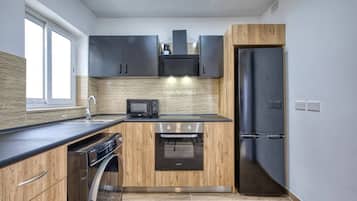 A modern kitchen with a built-in oven, microwave, and dishwasher.