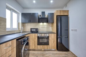 A modern kitchen with a built-in oven, microwave, and dishwasher. - Modern, Central 1BR Penthouse – Valletta View (Tal-Pietà)