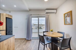 A modern apartment with a balcony, a dining area, and a kitchen. - Modern, Central 1BR Penthouse – Valletta View (Tal-Pietà)