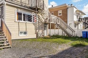 A residential building with a wooden staircase leading to a second-floor balcony. - 2 beds | AC | Smart TV Netflix | Près Vieux-Québec (Québec)