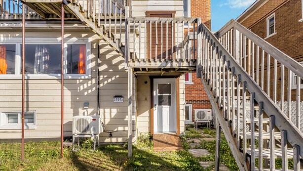 Un edificio residencial con una escalera de madera que lleva a una puerta con el letrero '1919A'.