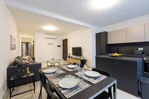 Eine moderne Wohnung mit Essbereich, Wohnzimmer und Küchenzeile.