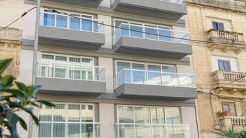 Un edificio residenziale a più piani con balconi, ampie finestre e un'entrata per garage.
