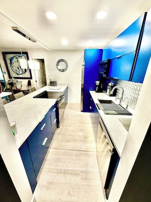 A modern kitchen with a central island, a microwave, and a sink. - Stylish 2BR/2BA  5 Guests Free Parking & Balcony 1 Block to Beach (Sunny Isles Beach)