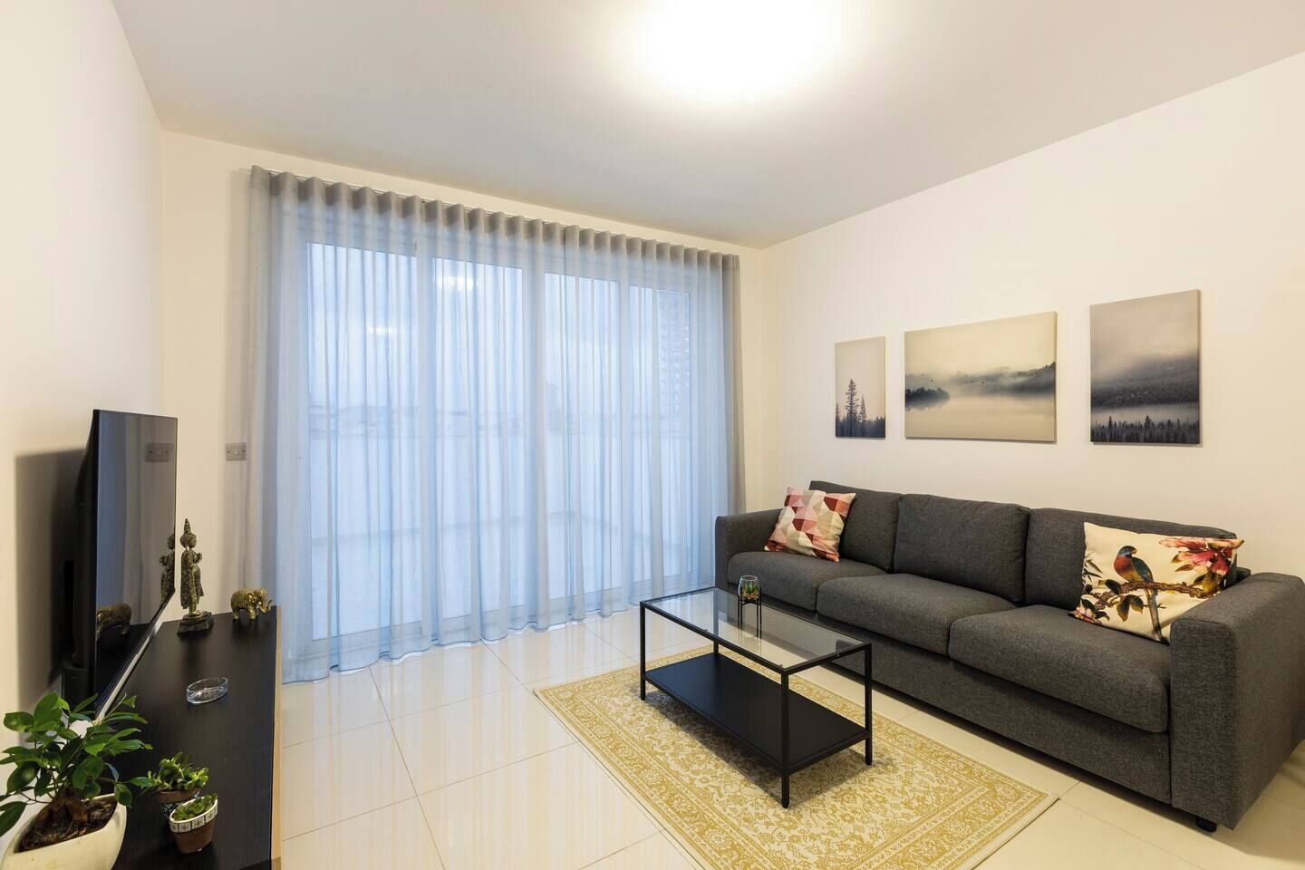 Una sala de estar moderna con un sofá, una mesa de centro y una obra de arte en la pared.