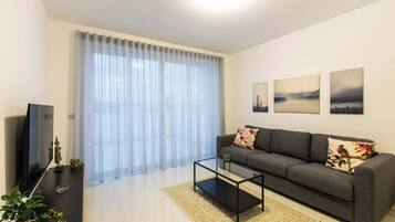 Una sala de estar moderna con un sofá, una mesa de centro y una obra de arte en la pared.