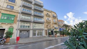 Un immeuble à plusieurs étages doté de balcons, d’une entrée au niveau du sol et d’une devanture visible.