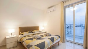 Une chambre d’hôtel équipée d’un lit, de tables de chevet, d’une fenêtre avec vue et d’un appareil de climatisation.