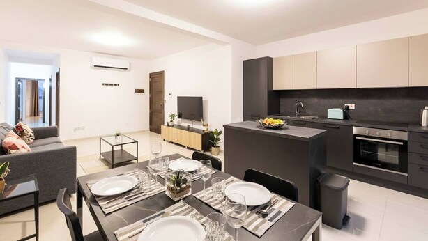 Un appartement moderne comprenant un coin repas, une cuisine et un espace de vie.
