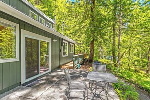 A cabin with a patio, outdoor seating, and a forested backdrop. - Harry's Hideaway | Hot Tub | Fire pit | Mt Rainier (Packwood)