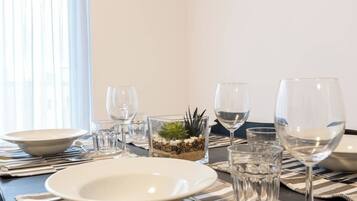 A dining table set with plates, glasses, and a decorative centerpiece.