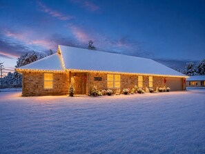 Een gebouw bedekt met sneeuw, met een bakstenen gevel, meerdere ramen en een besneeuwd dak.