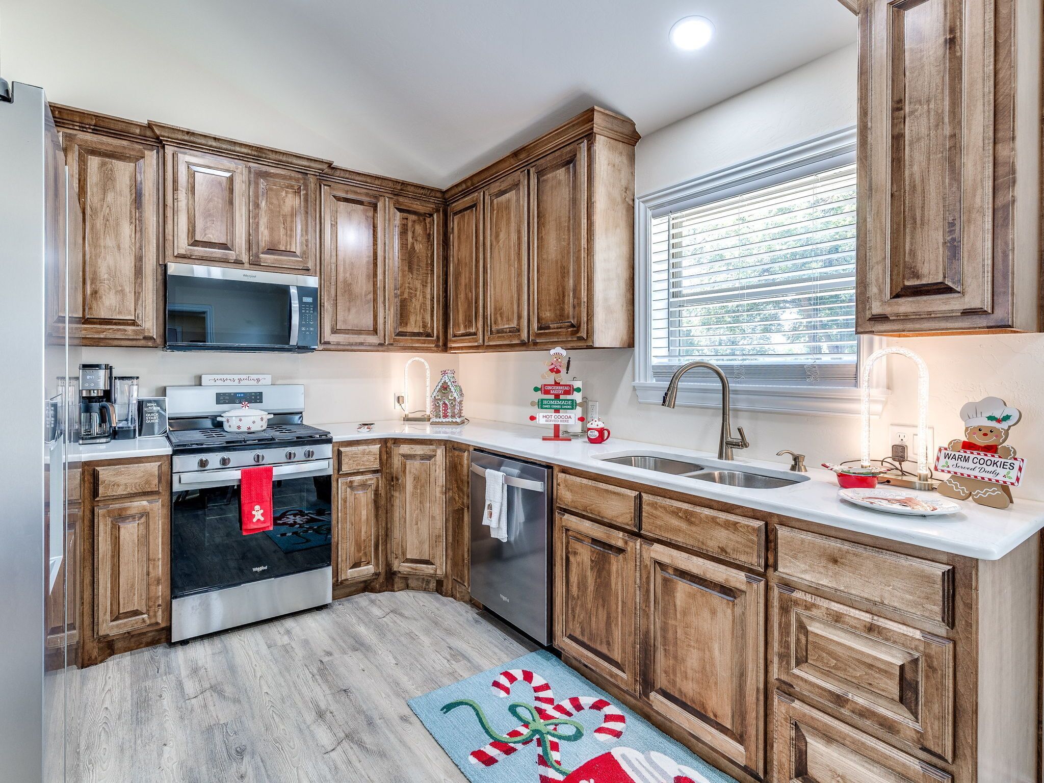 A kitchen with wooden cabinets, a stainless steel stove, a microwave, and a dishwasher.