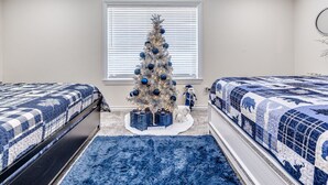 Un dormitorio con dos camas, un árbol de Navidad y un ventilador de techo.