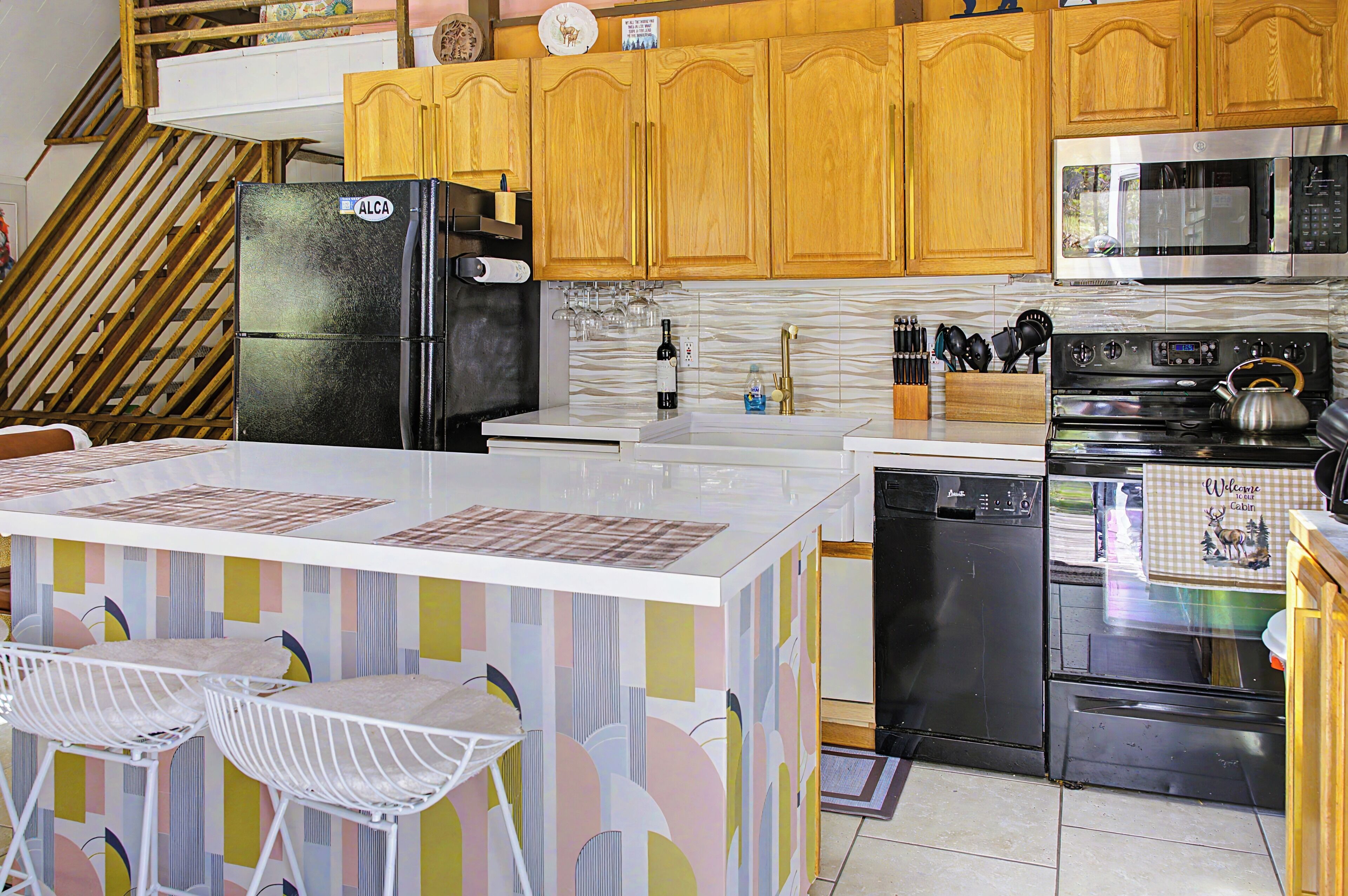 A kitchen with wooden cabinets, a black refrigerator, a microwave, a stove, and a dishwasher.