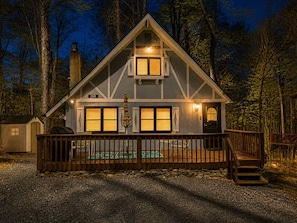 A two-story cabin with a deck, a covered pool, and a chimney. - Serenity Chalet in Arrowhead Lake (Pocono Lake)