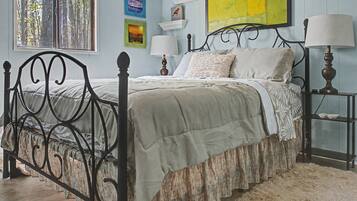A bed with a headboard, bedside tables with lamps, and wall art.