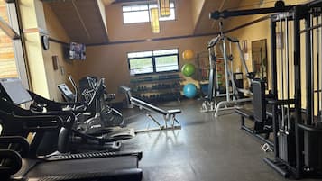 A gym with treadmills, weight machines, and exercise balls.