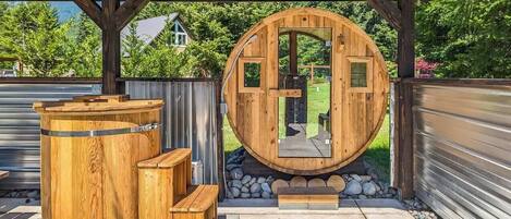 A wooden structure with a circular opening, benches, and a stone pathway.