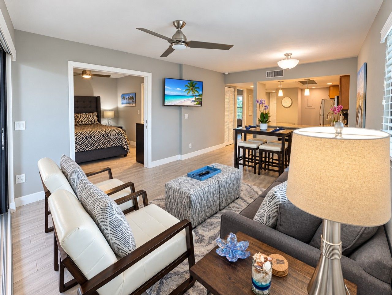 A spacious living area with a ceiling fan, a sofa set, a coffee table, and a television.
