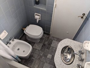 Ein kleines Badezimmer mit Toilette, Bidet und Waschbecken.