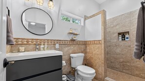 Ein Badezimmer mit Toilette, Waschbecken und Duschbereich.