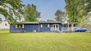 A single-story house with a porch, a small deck, and a large water tank in the yard. - Apartamento en Bloomington (Bloomington)