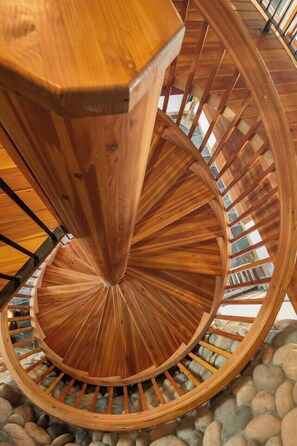 A spiral staircase with wooden steps and metal railings. - Private Mountain Chalet | Timberline | Mt. Rainier (Packwood)