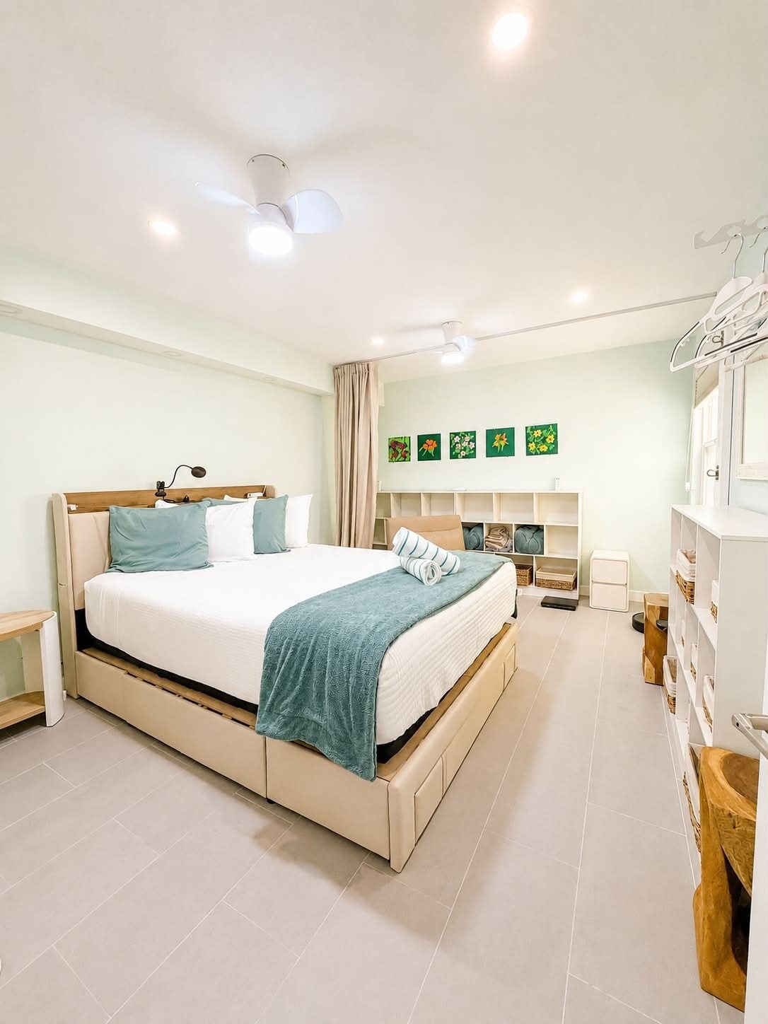 Een moderne slaapkamer met een groot bed, nachtkastjes, een garderobe en een plafondlamp.