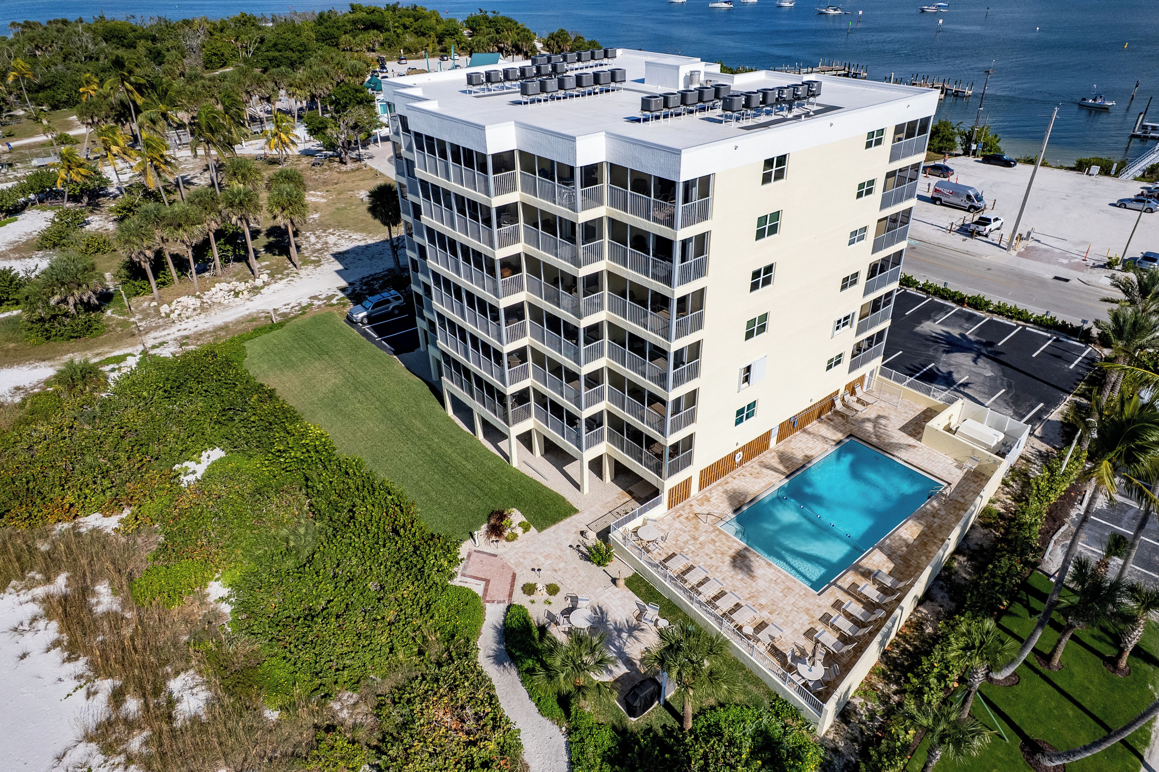 A multi-story hotel with a rooftop pool and a view of the sea.