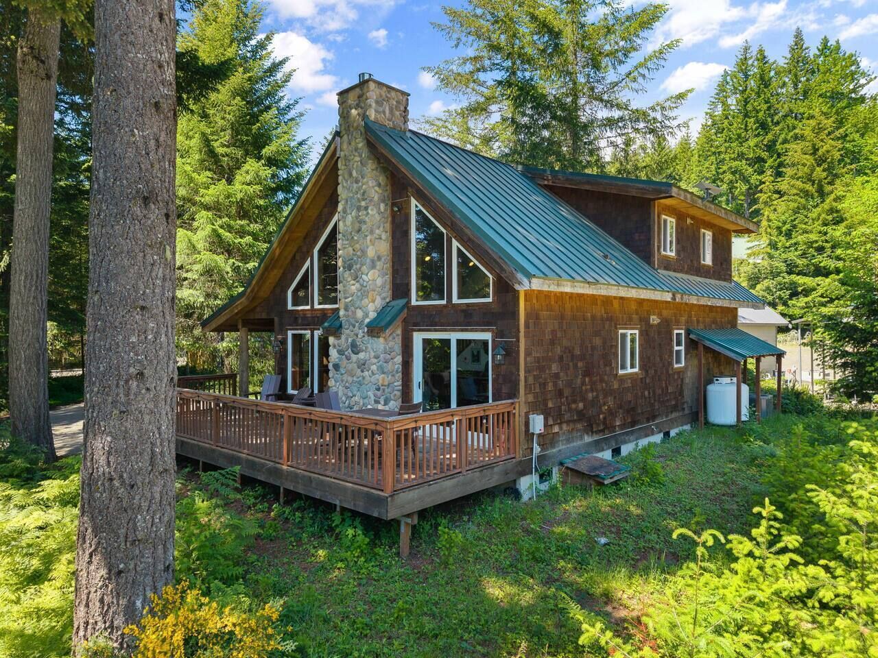 Eine Holzhütte mit Steinofen, einer Holzterrasse und einem Metalldach.