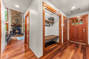 A room with a fireplace, wooden flooring, and a door with a window. - River Rock Retreat | Hot Tub+A/C | Mt Rainier (Packwood)