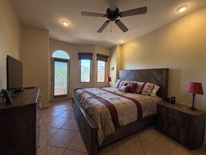 A bedroom with a bed, a ceiling fan, a TV, and a desk. - Bella Sirena B-202 (Puerto Peñasco)