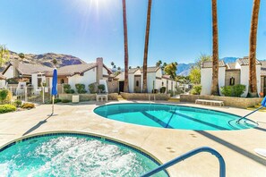A pool area with two swimming pools, palm trees, and a mountainous backdrop. - Canyon Sands Beauty (Palm Springs)