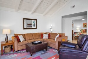 A living room with a sectional sofa, a leather armchair, a coffee table, and a lamp. - Canyon Sands Beauty (Palm Springs)