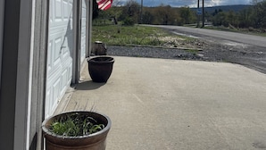 Eine Garage mit weißer Fassade, einem Blumentopf und einer US-amerikanischen Flagge.